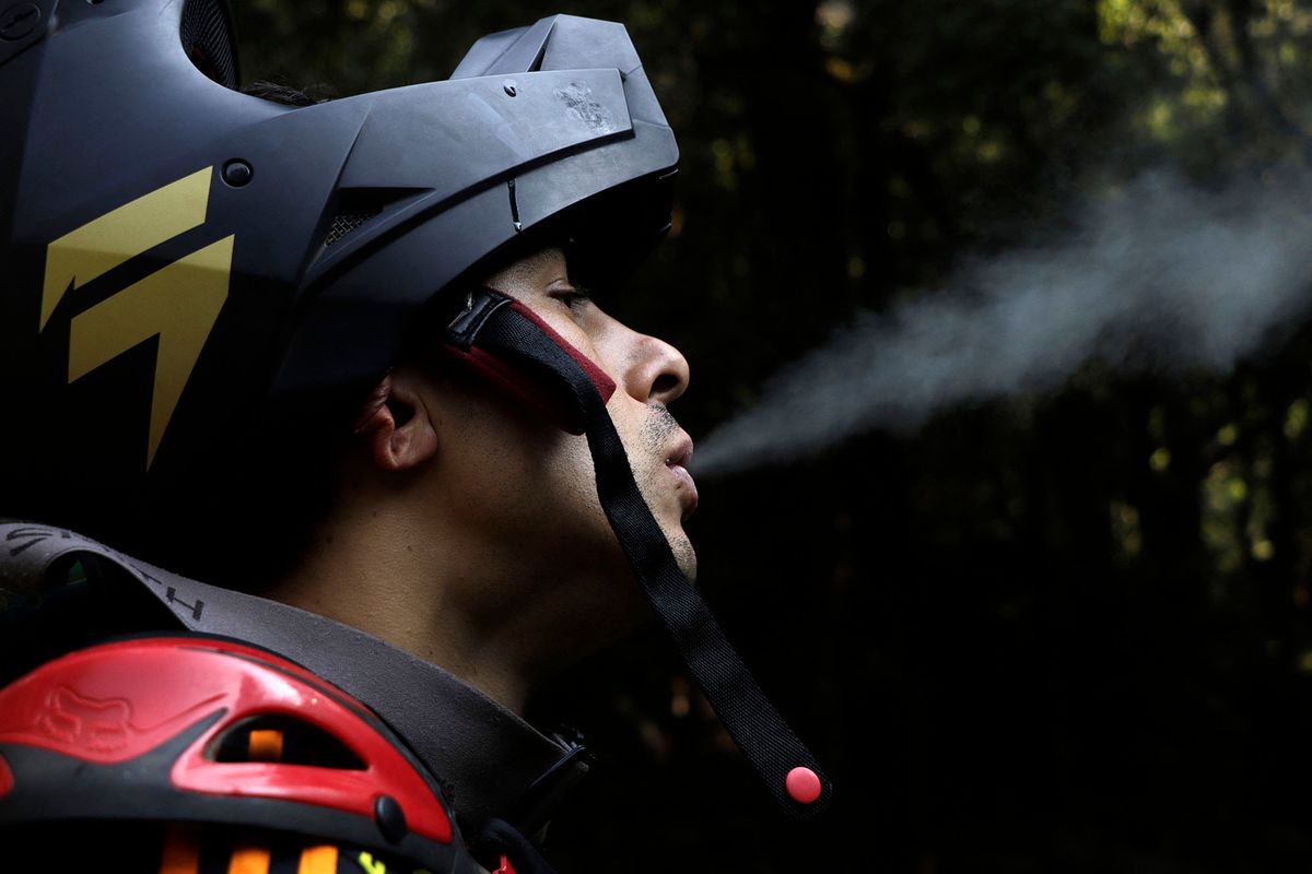 Gerardo Reyna, originally from the Iztapalapa mayor's office, expels smoke from an electronic cigarette prior to his mountain biking training on the La Resbalosa track in Los Dinamos in Mexico City during the Covid-19 health emergency in Mexico on May 29, 2020.  (Photo by Gerardo Vieyra/NurPhoto) (Photo by Gerardo Vieyra / NurPhoto / NurPhoto via AFP)