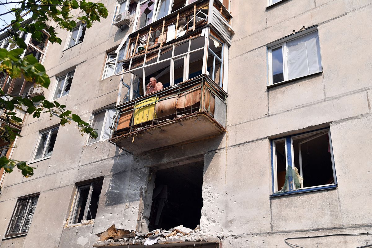 8214822 11.06.2022 A man smokes on the balcony of a residential building damaged by shelling in Severodonetsk, Luhansk People's Republic. Viktor Antonyuk / Sputnik (Photo by Viktor Antonyuk / Sputnik / Sputnik via AFP)