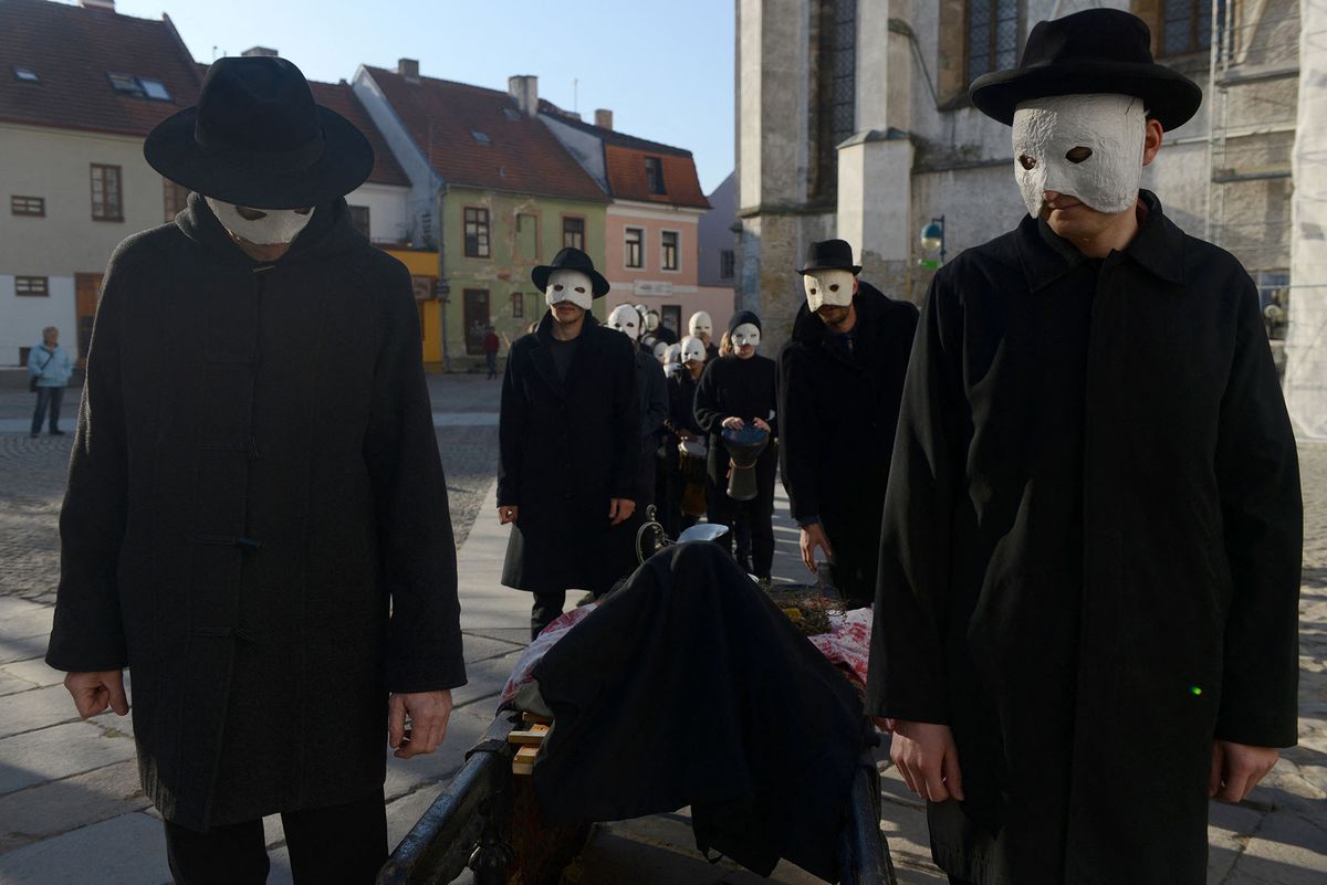 People, wearing white masks, carry a funeral bier during a Czech Easter traditional ritual to mark Good Friday, that recalls for Christians the crucifixion of Jesus Christ ahead of Easter Sunday, on April 19, 2019 in Ceske Budejovice. - Christians around the world are marking the Holy Week, commemorating the crucifixion of Jesus Christ, leading up to his resurrection on Easter. (Photo by Michal CIZEK / AFP)