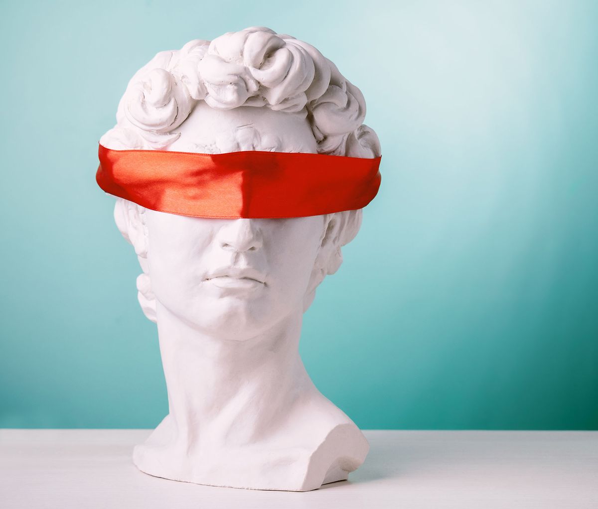 Plaster,Head,With,Eyes,Covered,Red,Satin,Ribbon,On,BluePlaster head with eyes covered red satin ribbon on blue background. Avoid problems concept.