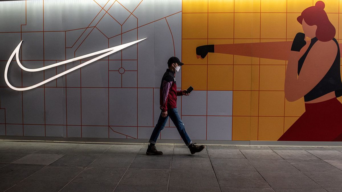 A man walks past a Nike store in Beijing on April 5, 2021. (Photo by NICOLAS ASFOURI / AFP)