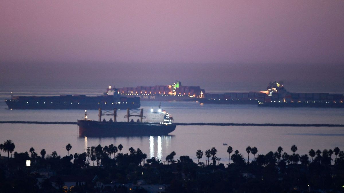 Cargo shipping container ships wait in the Pacific Ocean to enter the Port of Los Angeles and Port of Long Beach on October 15, 2021 as seen before sunrise from Signal Hill, California. - The port, North America's busiest container terminal, began 24-hour operations October 14, 2021 after the White House intervened to help ease bottlenecks that are choking commerce and pushing up prices. (Photo by Patrick T. FALLON / AFP)
