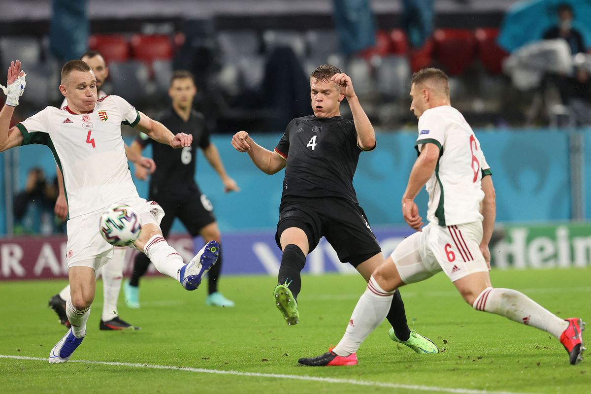 Hungary's defender Attila Szalai (L) and Germany's defender Matthias Ginter (C) vie for the ball during the UEFA EURO 2020 Group F football match between Germany and Hungary at the Allianz Arena in Munich on June 23, 2021. (Photo by ALEXANDER HASSENSTEIN / POOL / AFP)