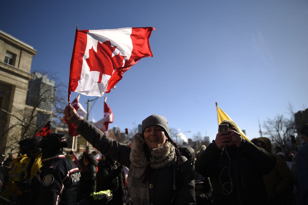 A protester waiving Canadian National flag during the protest at Queens Park to support the truckers and denounce the government policy of mandatory vaccination in Toronto, Canada (Photo by Arindam Shivaani/NurPhoto) (Photo by Arindam Shivaani / NurPhoto / NurPhoto via AFP)