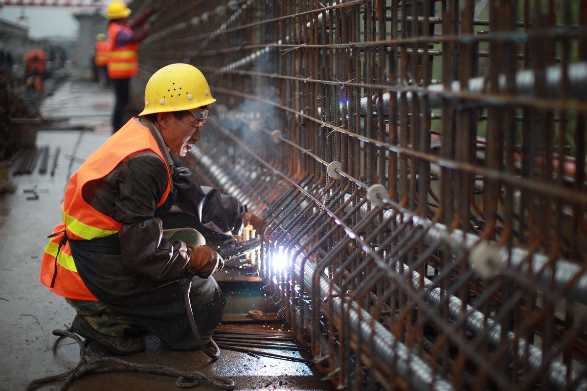 (201002) -- GUIYANG, Oct. 2, 2020 (Xinhua) -- Zhang Feng of China Tiesiju Civil Engineering Group welds components at the construction site of a highway expansion project in Zunyi, southwest China's Guizhou Province, Oct. 2, 2020. Many Chinese have contributed their holiday to work during the National Day Holiday. (Xinhua/Liu Xu) (Photo by Liu Xu / XINHUA / Xinhua via AFP)