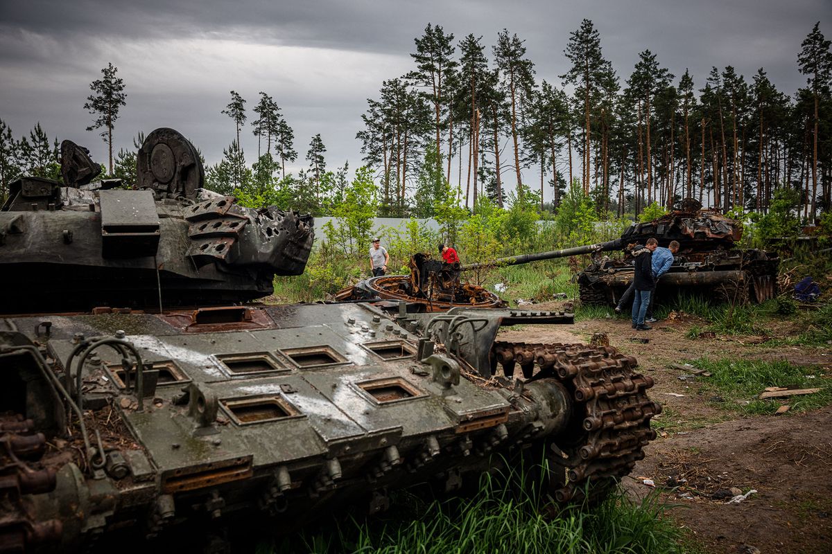 Local residents examine a destroyed Russian tank outside Kyiv on May 31, 2022, amid the Russian invasion of Ukraine. (Photo by Dimitar DILKOFF / AFP)