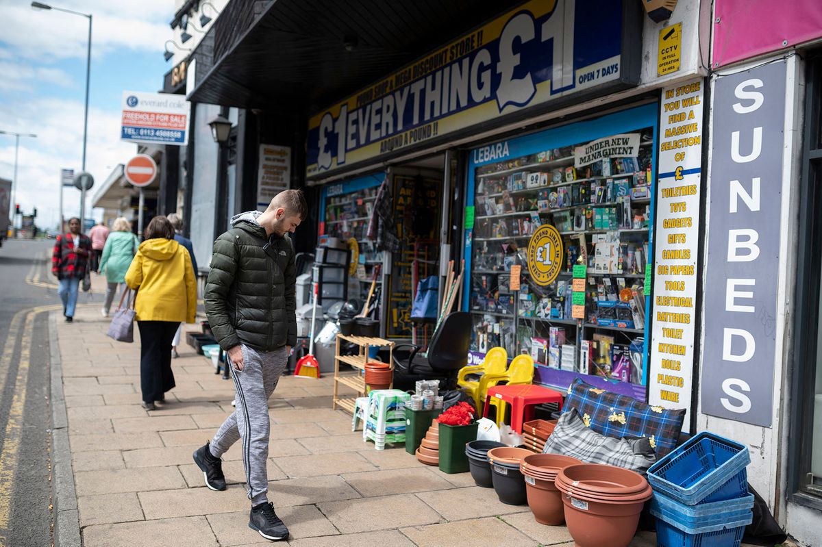 A man walks past a discount store in the city centre of Bradford in northern England on May 24, 2022. - Bradford Central Foodbank is helping twice as many people compared to pre-pandemic, as spiralling prices for energy, food and other basics leave a growing number of Britons struggling. (Photo by OLI SCARFF / AFP) / TO GO WITH AFP STORY BY JOE JACKSON