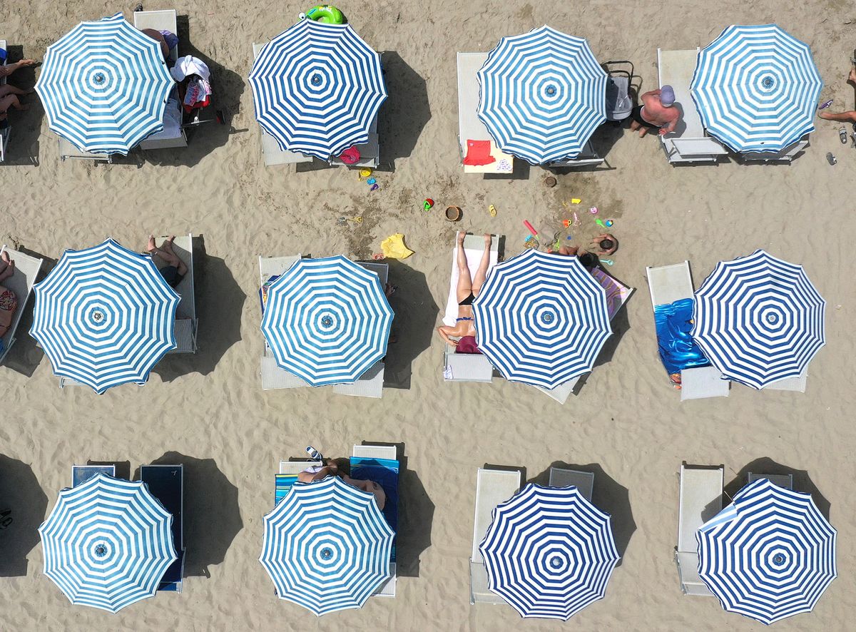 This aerial view taken in Durres on June 25, 2021, shows tourists sunbathing on the beach. - The heat wave hit Albania where temperatures reach a peak of 42 degrees Celsius. (Photo by Gent SHKULLAKU / AFP)