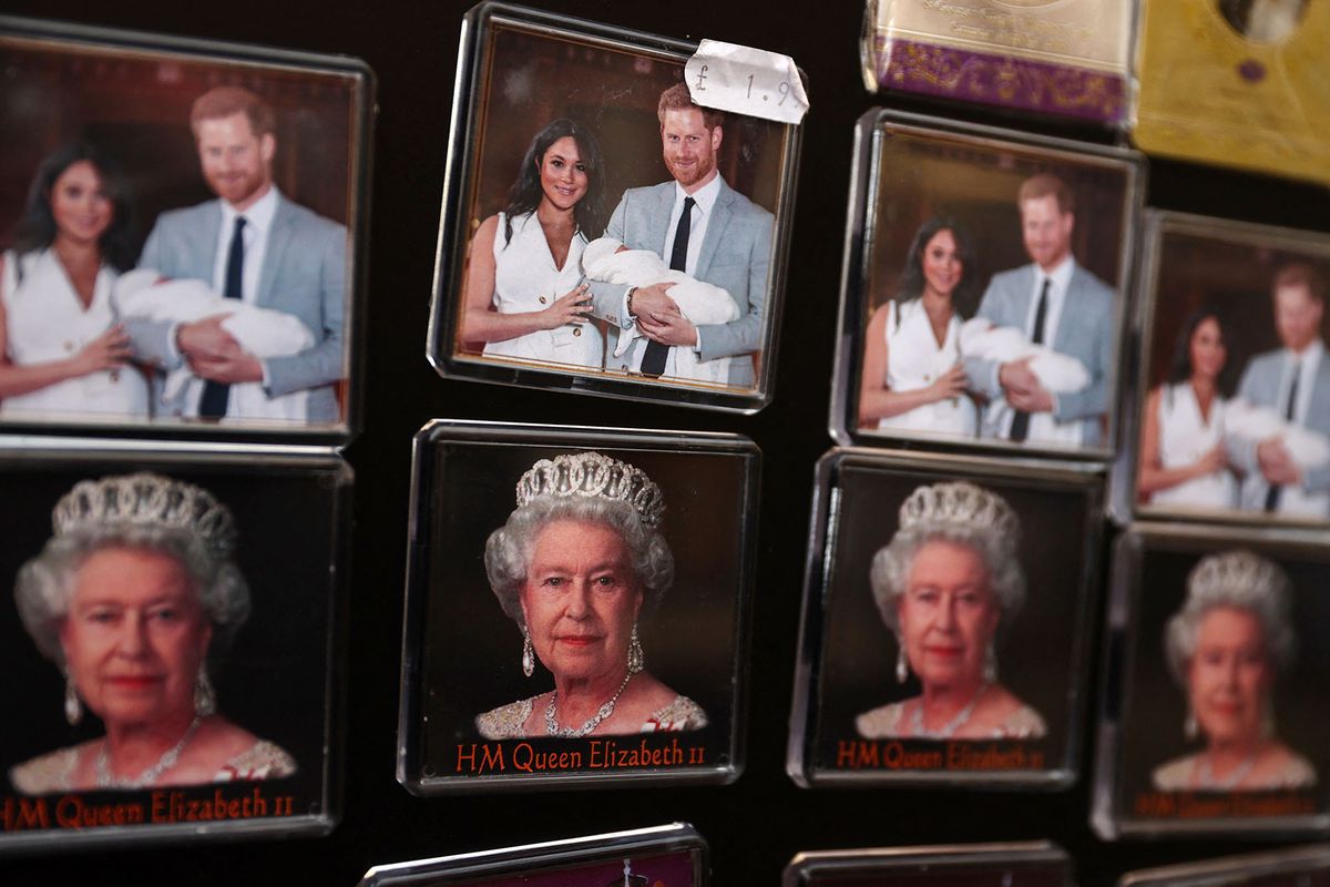 Fridge magnets featuring Britain's Queen Elizabeth II and Prince Harry with his wife Meghan Markle are displayed outside a souvenir shop opposite Windsor Castle on February 17, 2022. - Disgraced British royal Prince Andrew was urged to disappear forever from public life after settling a sexual assault lawsuit at vast cost, as Queen Elizabeth II suffered further indignity in her Platinum Jubilee year. (Photo by ADRIAN DENNIS / AFP)