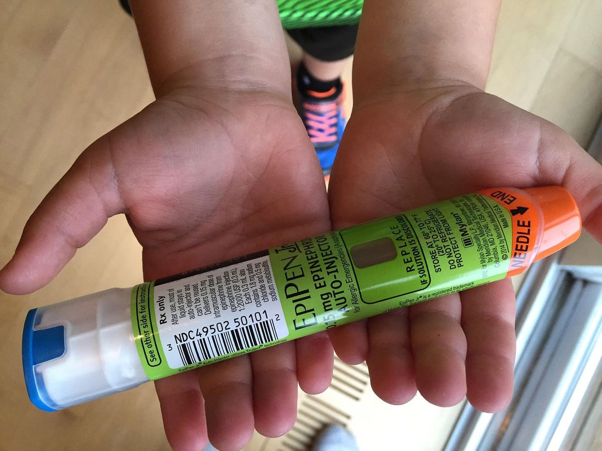This August 24, 2016 photo taken in Hudson, Wisconsin shows a youngster holding Epipens, that he uses to counteract allergic reactions. - A five-fold price hike for EpiPen, which allergy sufferers use to counteract life-threatening reactions, has made Mylan the newest drugmaker to come under attack in the United States for profiteering. Mylan Pharmaceuticals, which holds a near-monopoly position on the epinephrine injectors used by millions against severe allergic attacks, was assailed by two powerful US senators for pumping up the price over six years from $100 to more than $500. That has rendered EpiPens unaffordable to many sufferers -- who must replace them each year -- and is costing the government huge sums to stock schools with them and fund insurance programs which pay for them, the lawmakers said Monday. (Photo by Lucas TRIEB / AFP)