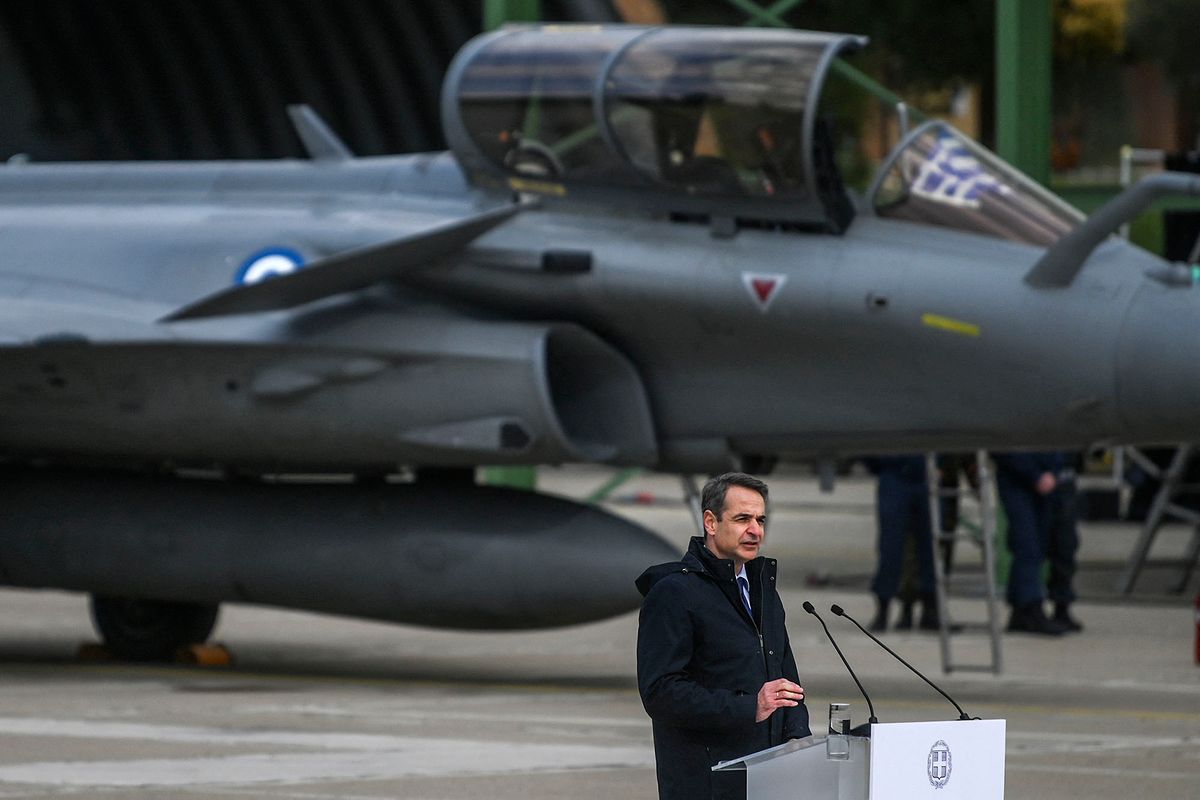 Greek Prime Minister Kyriakos Mitsotakis delivers a speech during a ceremony following the arrival of the first Rafale jet fighters at the Tanagra military air base, north of Athens, on January 19, 2022. - Greece took delivery on January 19 of the first six Rafale jets in a multi-billion arms deal which Athens and Paris claim boosts the EU's defence ambitions, whilst also serving to counter Turkish ambitions in the Mediterranean. The six warplanes landed at Tanagra airbase, some 70 kilometres (43 miles) north of Athens after overflying the Acropolis, escorted by Greek Mirage jets, a prior purchase from France. (Photo by Angelos Tzortzinis / AFP)