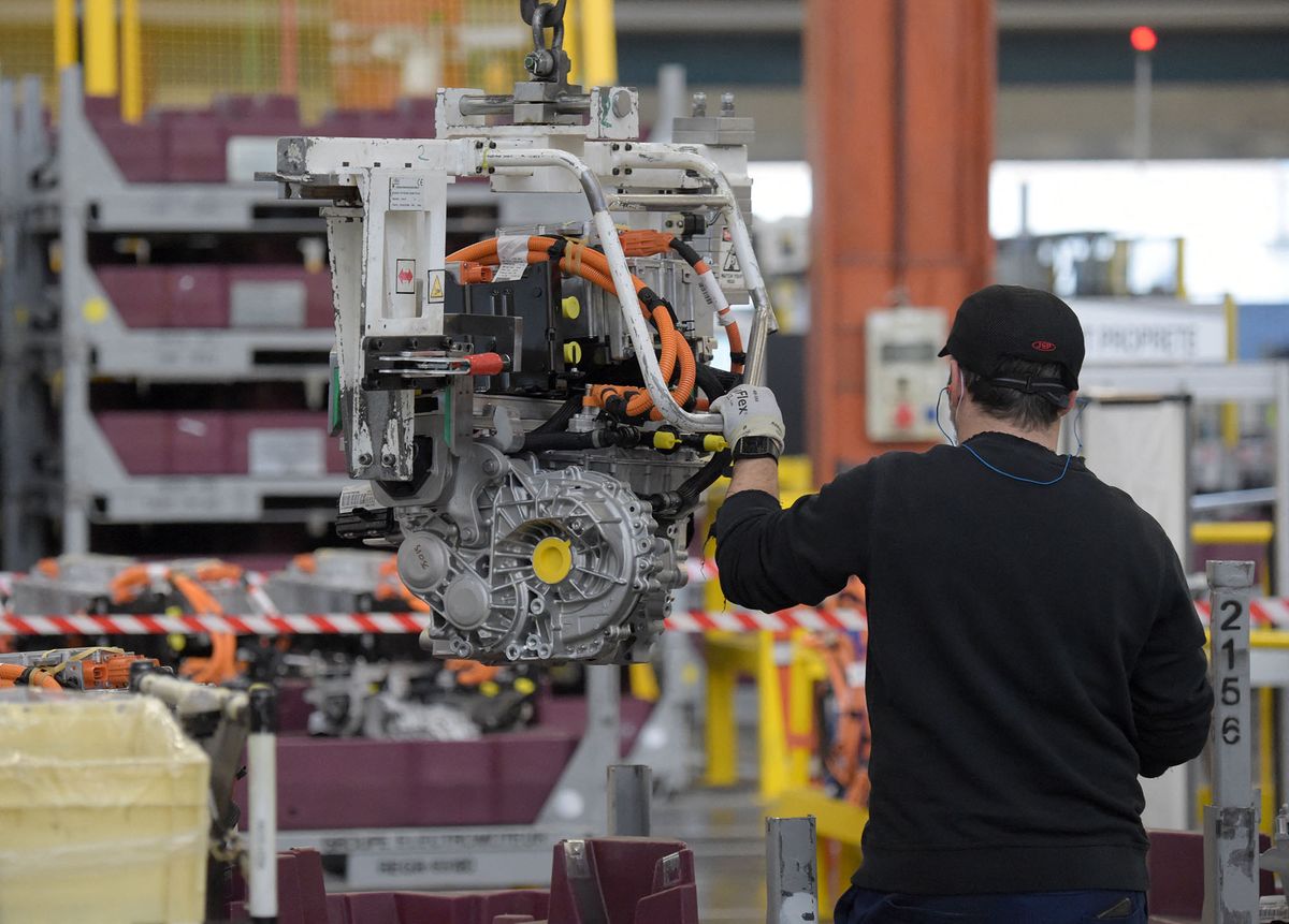 An employee works on an electric engine assembly line at automaker Stellantis plant in Tremery, eastern France, on January 27, 2022. - Stellantis, a company from the merger of Fiat Chrysler and PSA, creates the 4th largest automobile group in the world. (Photo by Eric PIERMONT / AFP)