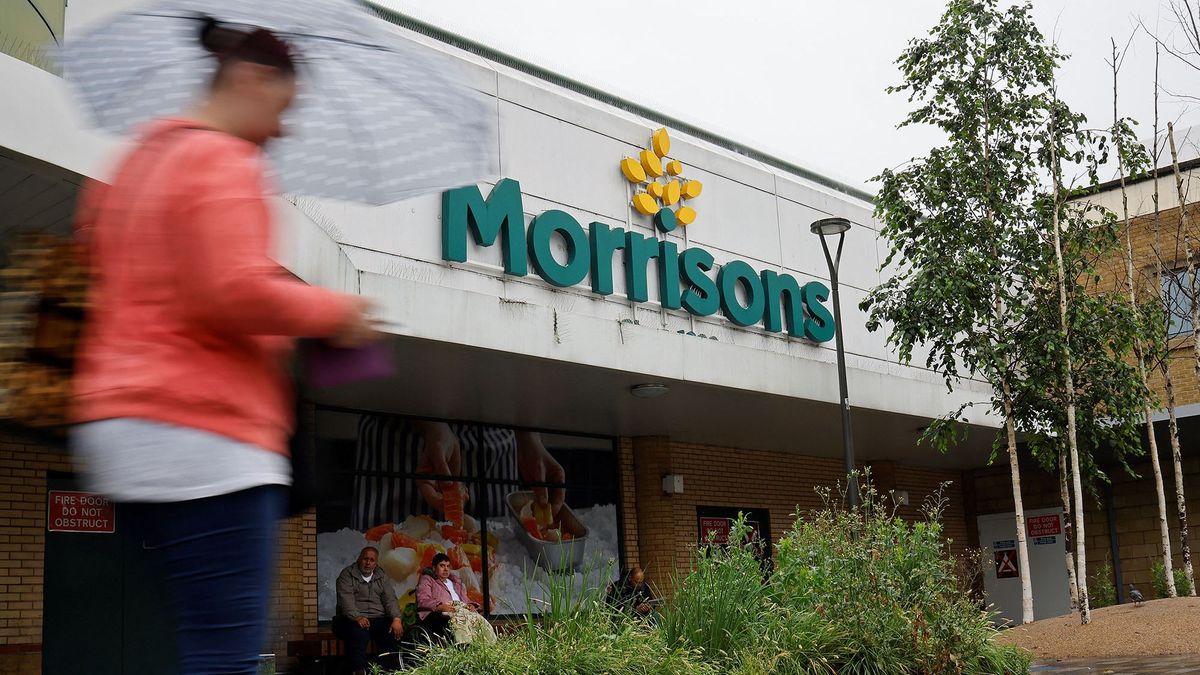 A woman walks past a Morrisons supermarket in Stratford, east London on June 21, 2021. - Shares in British supermarket chain Morrisons surged today after it rejected a £5.5-billion ($7.6-billion, 6.4-billion-euro) takeover approach as too low. (Photo by Tolga Akmen / AFP)