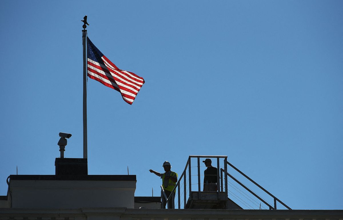 A worker is seen on the roof of the White House as it undergoes renovations on August 9, 2017 in Washington, DC. (Photo by MANDEL NGAN / AFP)