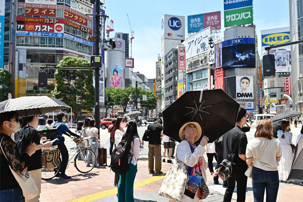 TOKYO, JAPAN - JUNE 27: People walk on the street using an umbrella to protect themselves from the sun on June 27, 2022, in Tokyo's popular Shibuya district in Tokyo, Japan.  The capital of Japan has been swept by a heat wave for the past few days with temperatures well above 30 degrees Celsius. David Mareuil / Anadolu Agency (Photo by david mareuil / ANADOLU AGENCY / Anadolu Agency via AFP)