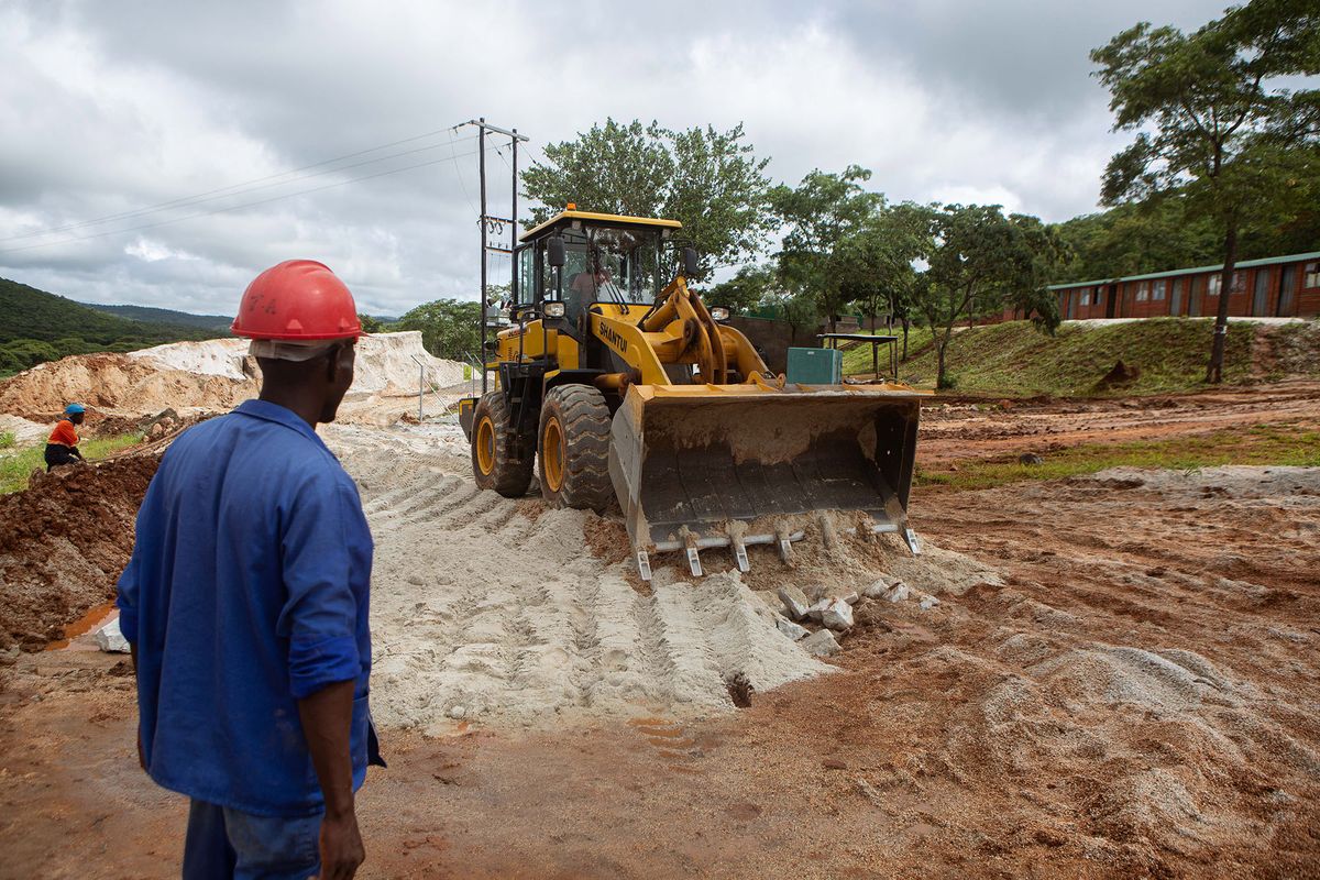 1237664391 GOROMONZI, ZIMBABWE - JANUARY 11: A foreman looks on as a bulldozer works on the slippery road at Arcadia Lithium  mine on January 11, 2022 in Goromonzi, Zimbabwe. Last month, the Chinese firm Zhejiang Huayou Cobalt said it would pay over $400 million for the hard-rock lithium mine, whose product is a key ingredient in rechargeable batteries used in electric vehicles. The world's transition to "clean energy" may strain global mining capacity to produces these minerals.  (Photo by Tafadzwa Ufumeli/Getty Images)