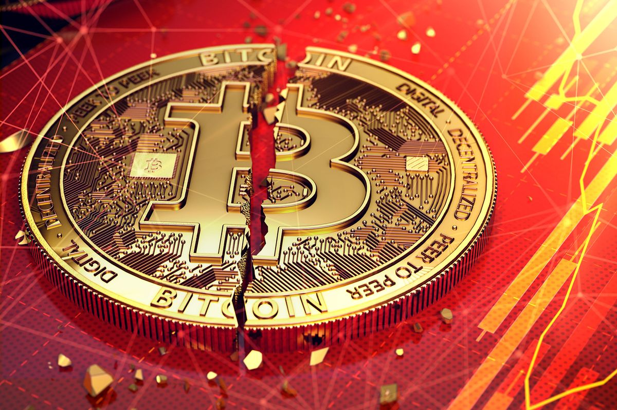 Broken bitcoin split in two pieces laying on a screen. The screen has red diagram. Bitcoin decline concept. 3D rendering