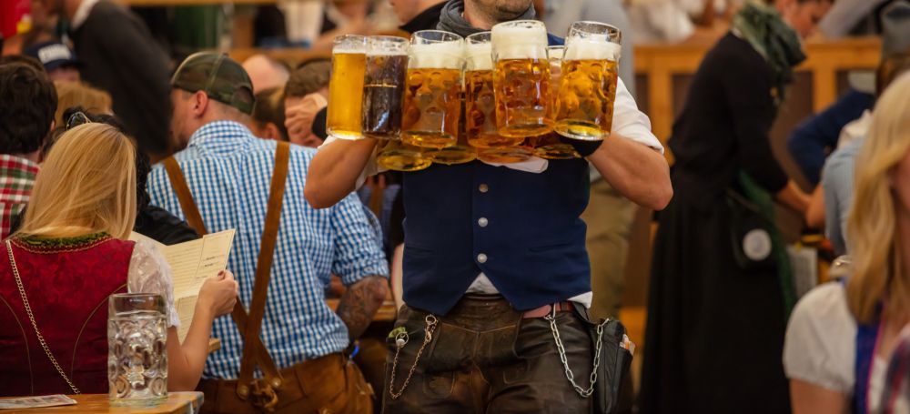 Oktoberfest,,Munich,,Germany.,Waiter,With,Traditional,Costume,Serving,Beers,,Closeup