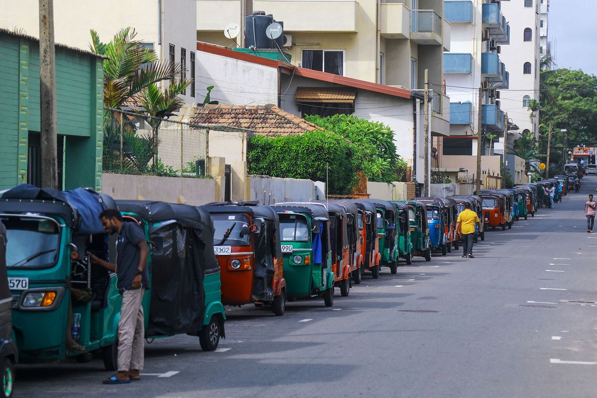 Autorickshaw drivers queue along a street to buy petrol from a Ceylon petroleum corporation fuel station in Colombo on June 15, 2022. (Photo by AFP)