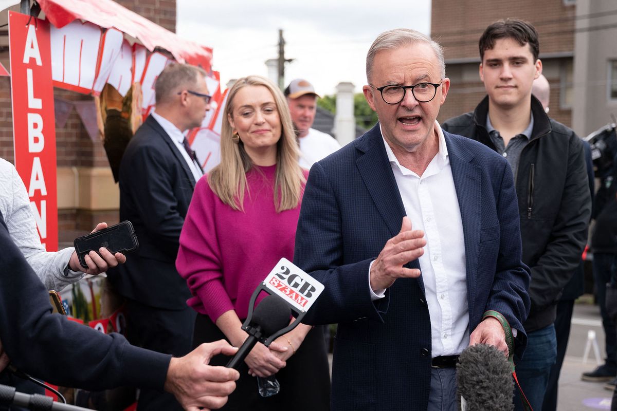 Opposition Labor Party leader Anthony Albanese (C), accompanied by his partner Jodie Haydon (front L) and son Nathan Albanese (C), speaks to media outside a polling station during Australia's general election in the suburb of Marrickville in Sydney on May 21, 2022. (Photo by Wendell Teodoro / AFP)