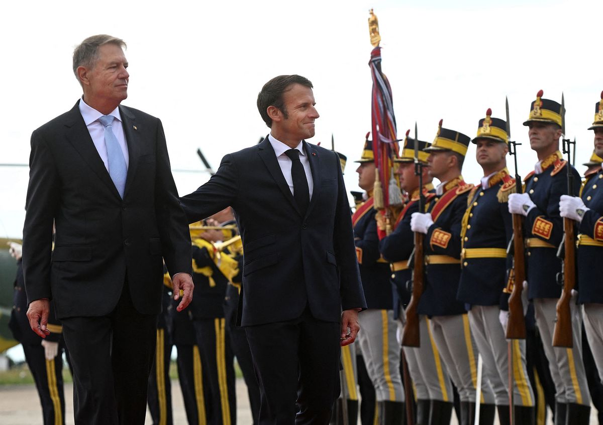 French President Emmanuel Macron (R) and Romanian President Klaus Iohannis (L) review a military honour guard during an official welcoming ceremony at the Mihail Kogalniceanu Air Base, near the city of Constanta, on June 15, 2022. - Macron called for "new in-depth discussions" with Ukraine, without confirming if he would travel this week to Kyiv as several media have reported. (Photo by Daniel MIHAILESCU / AFP)