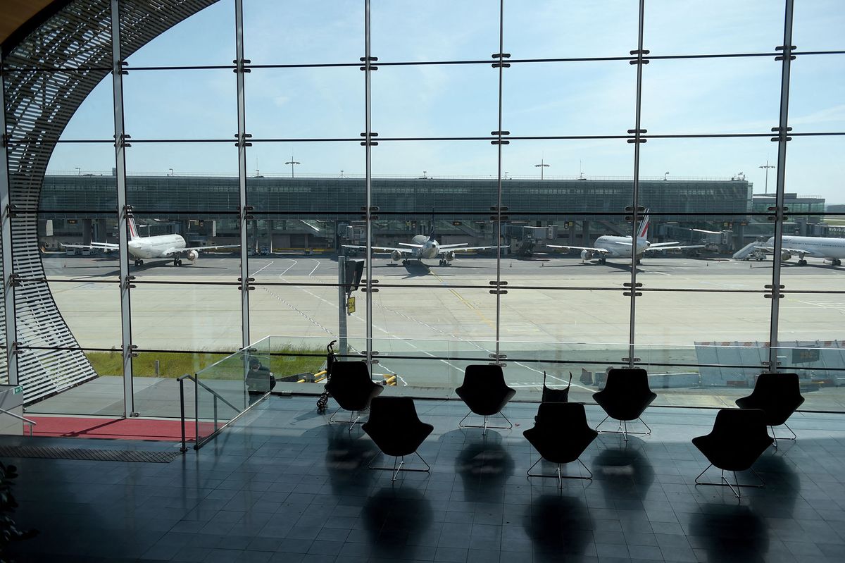 (FILES) In this file photo taken on May 12, 2020 a window shows planes on the tarmac at the Terminal 2E at the Paris-Charles de Gaulle airport in Roissy-en-France. - A quarter of flights will be cancelled at the main Paris airport on June 9, 2022 as workers stage a strike to demand higher wages, airport operator ADP said. (Photo by ERIC PIERMONT / AFP)