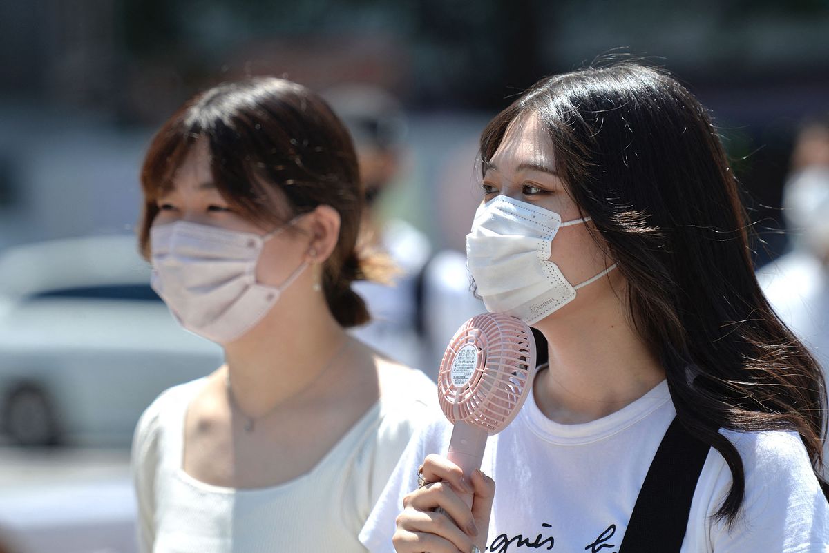 TOKYO, JAPAN - JUNE 27: A young woman is seen on the street using a portable fan to refresh herself on June 27, 2022, in Tokyo's popular Shibuya district in Tokyo, Japan.  The capital of Japan has been swept by a heat wave for the past few days with temperatures well above 30 degrees Celsius. David Mareuil / Anadolu Agency (Photo by david mareuil / ANADOLU AGENCY / Anadolu Agency via AFP)