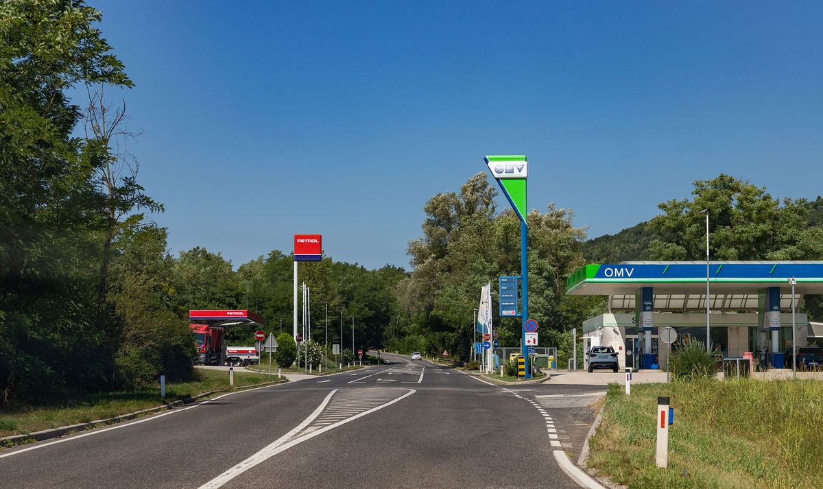A picture of two different gas stations - Petrol and OMV - facing each other in Slovenia.