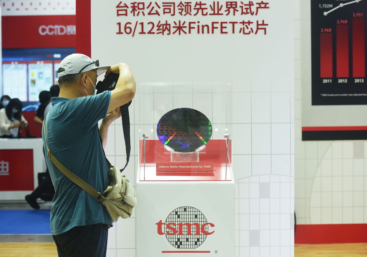 1322638956 NANJING, CHINA - JUNE 09: A visitor looks at a 300mm wafer at the booth of Taiwan Semiconductor Manufacturing Company Limited (TSMC) during 2021 World Semiconductor Conference at Nanjing International Expo Center on June 9, 2021 in Nanjing, Jiangsu Province of China. (Photo by Long Wei/VCG via Getty Images)