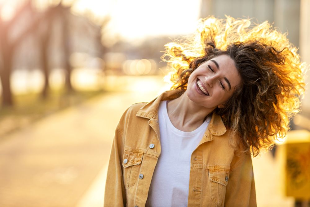 Portrait,Of,Young,Woman,With,Curly,Hair,In,The,City