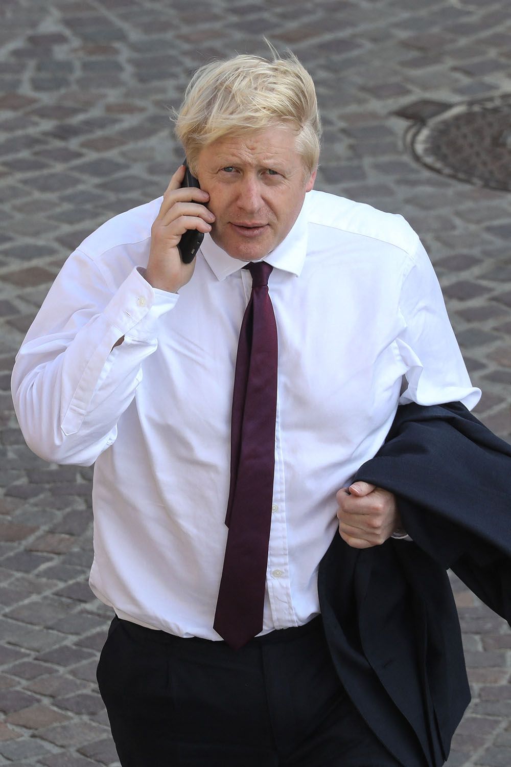 Britain's Prime Minister Boris Johnson speaks on his moble as he walks close to the sea front in Biarritz, south-west France on August 25, 2019, on the second day of the annual G7 Summit attended by the leaders of the world's seven richest democracies, Britain, Canada, France, Germany, Italy, Japan and the United States. (Photo by Ludovic MARIN / AFP)