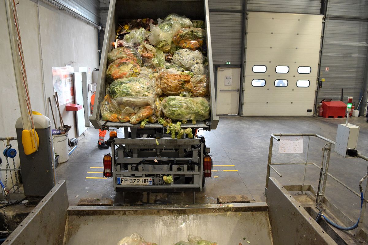 A truck of Moulinot downloads its bio-waste collect of fruits and legumes, at the company's site, in Stains, on November 19, 2021. - Moulinot is a company specialised in collecting and recycling bio-waste. (Photo by Eric PIERMONT / AFP)