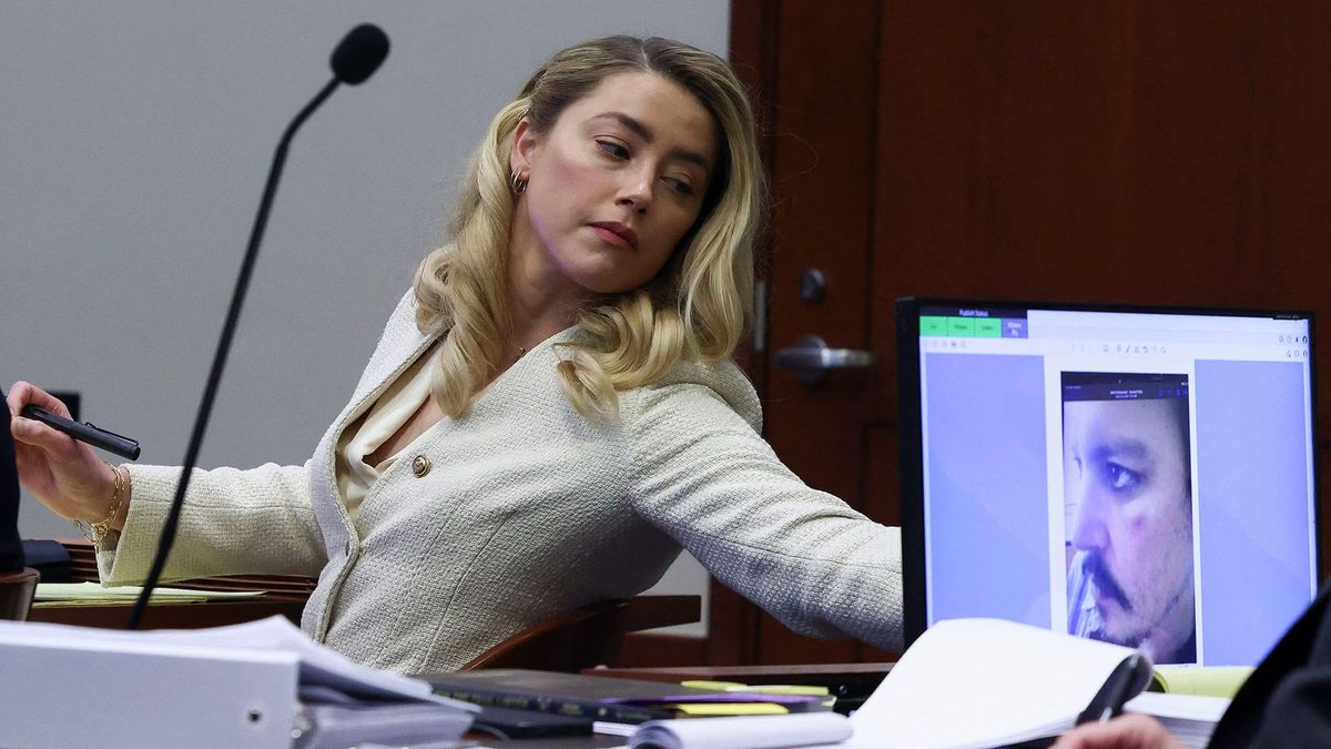 Actress Amber Heard listens to her ex-husband Johnny Depp, as a picture of an injury to his face is seen on a screen, during his defamation trial against her at the Fairfax County Circuit Courthouse in Fairfax, Virginia, April 20, 2022. - Depp is suing ex-wife Heard for libel after she wrote an op-ed piece in The Washington Post in 2018 referring to herself as a ìpublic figure representing domestic abuse.î (Photo by EVELYN HOCKSTEIN / POOL / AFP)