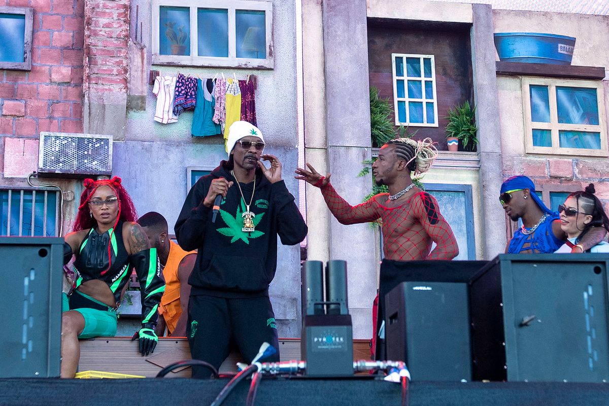 US rapper Snoop Dogg smokes as he performs onstage with Brazilian singer Anitta (out of frame) during the Coachella Valley Music and Arts Festival in Indio, California, on April 15, 2022. (Photo by VALERIE MACON / AFP)