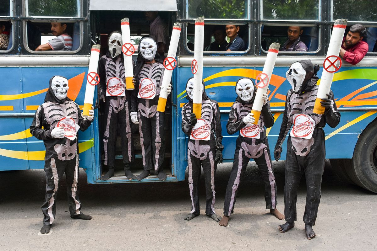People are seen dressed in skelton costume and carrying a figurine of cigarette to raise awareness towards adverse effects of smoking on world no-tobacco day , in Kolkata , India , on 31 May 2022 . (Photo by Debarchan Chatterjee/NurPhoto) (Photo by Debarchan Chatterjee / NurPhoto / NurPhoto via AFP)