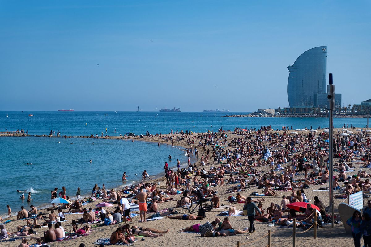 A crowded Barceloneta beach is seen on a sunny day as the tourist season begins in the first year without significant Covid-19 pandemic restrictions in Barcelona, Spain, on May 13, 2022. Forecasts for the summer season 2022 see record numbers of visitors coming back to Spain, back to pre-pandemic levels. (Photo by Davide Bonaldo / Controluce via AFP)
