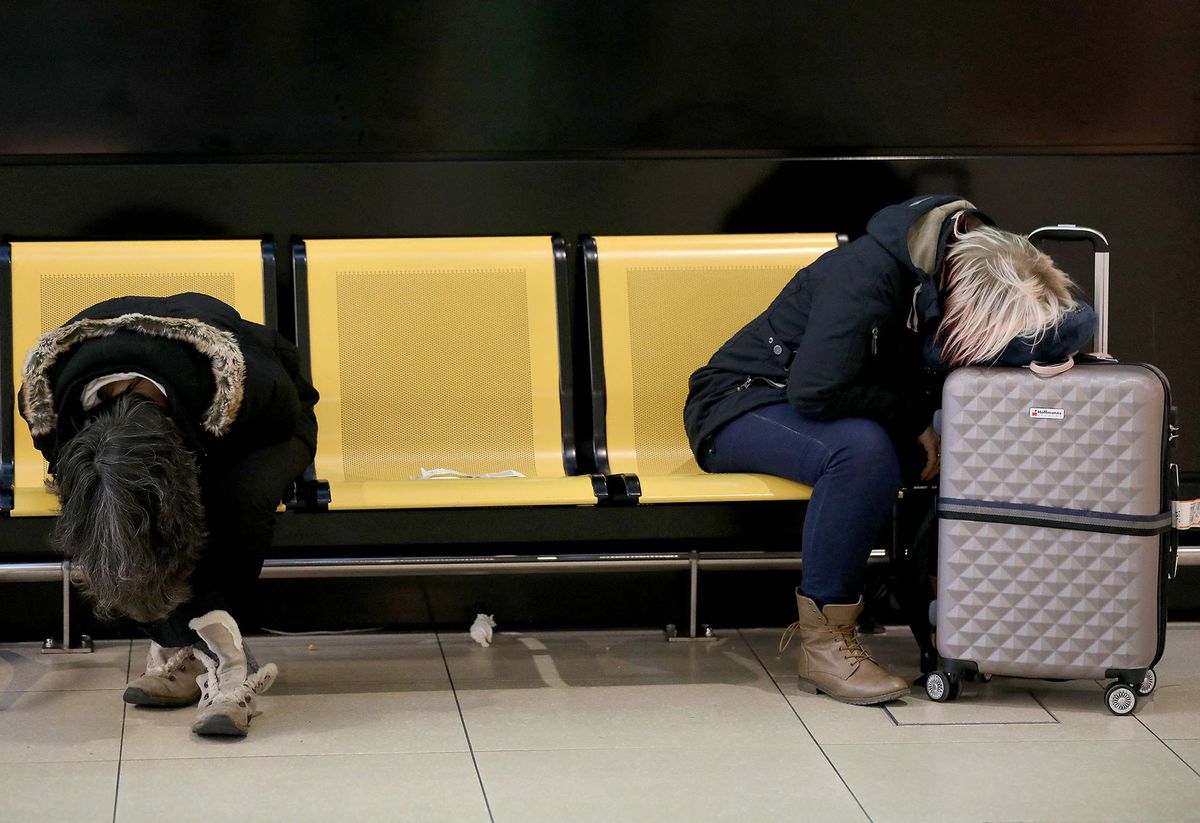 10 February 2020, North Rhine-Westphalia, Cologne: Passengers sleep at Cologne Bonn Airport. The storm depression "Sabine" has passed through North Rhine-Westphalia. Photo: Oliver Berg/dpa (Photo by OLIVER BERG / DPA / dpa Picture-Alliance via AFP)