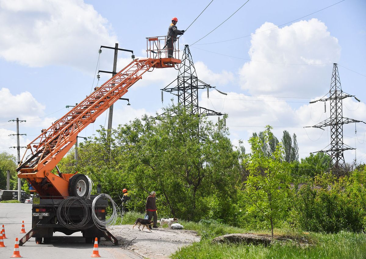 8192596 16.05.2022 Electricians remove parts of a power pole to rebuild power lines on one of the streets in Mariupol, Donetsk People's Republic. Alexey Kudenko / Sputnik (Photo by Alexey Kudenko / Sputnik / Sputnik via AFP)
