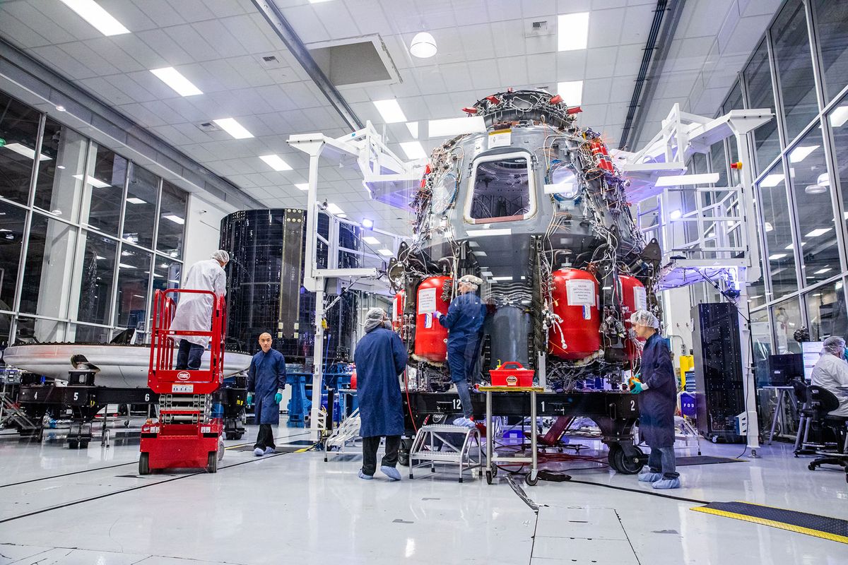 Employees of SpaceX work on the Crew Dragon reusable spacecraft after a press conference at SpaceX headquarters in Hawthorne, California on October 10, 2019. (Photo by Philip Pacheco / AFP)