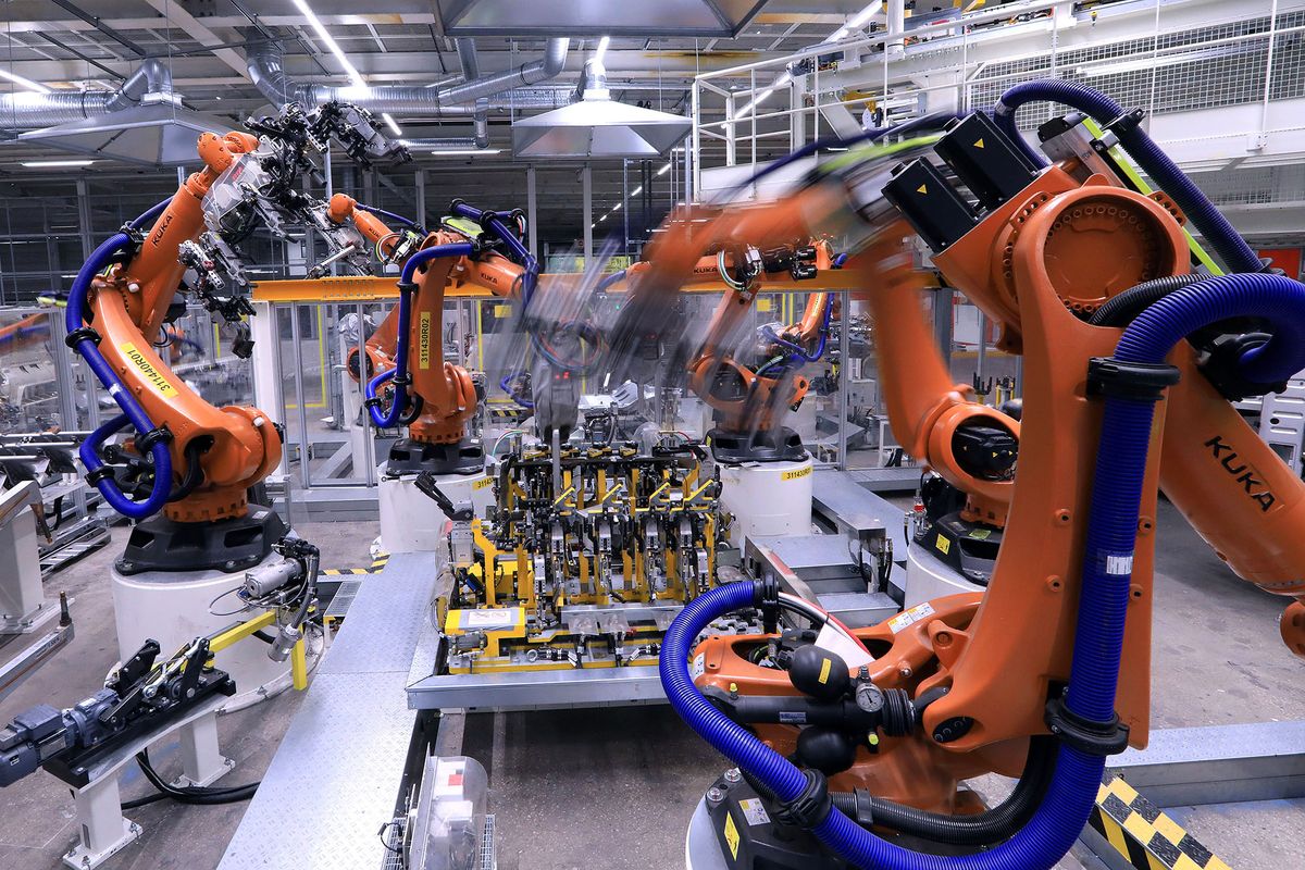 1203452018 Robotic arms manufactured by Kuka AG operate on chassis parts on the Volkswagen AG (VW) ID.3 electric automobile assembly line in Zwickau, Germany, on Tuesday, Feb. 25, 2020. The worlds largest automaker plans to eliminate carbon dioxide emissions by 2050 and will invest 33 billion euros through 2024 to build the industrys biggest fleet of electric cars. Photographer: Krisztian Bocsi/Bloomberg via Getty Images