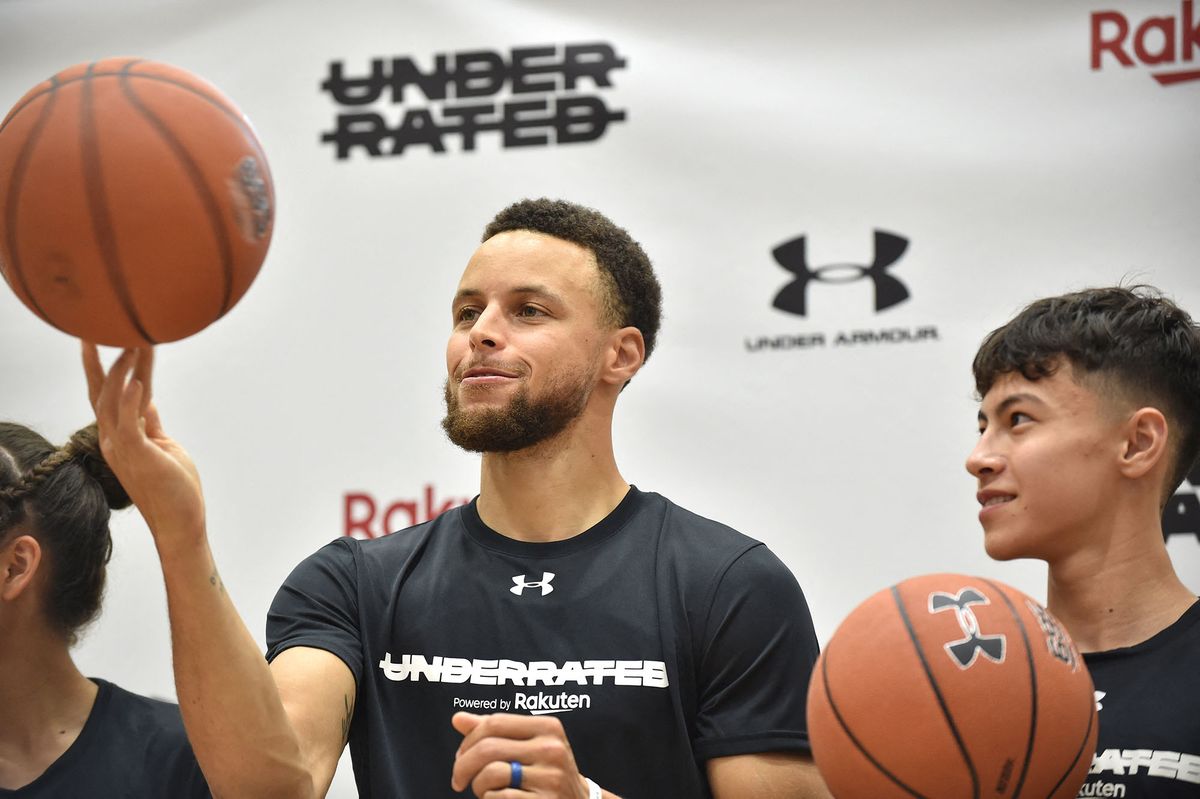 Stephen Curry (C), US basketball player from the Golden State Warriors of the National Basketball Association (NBA), plays his skills during a press conference following his Underrated Tour, a series of basketball camps for high school players, at a university in Tokyo on June 23, 2019. (Photo by Kazuhiro NOGI / AFP)
