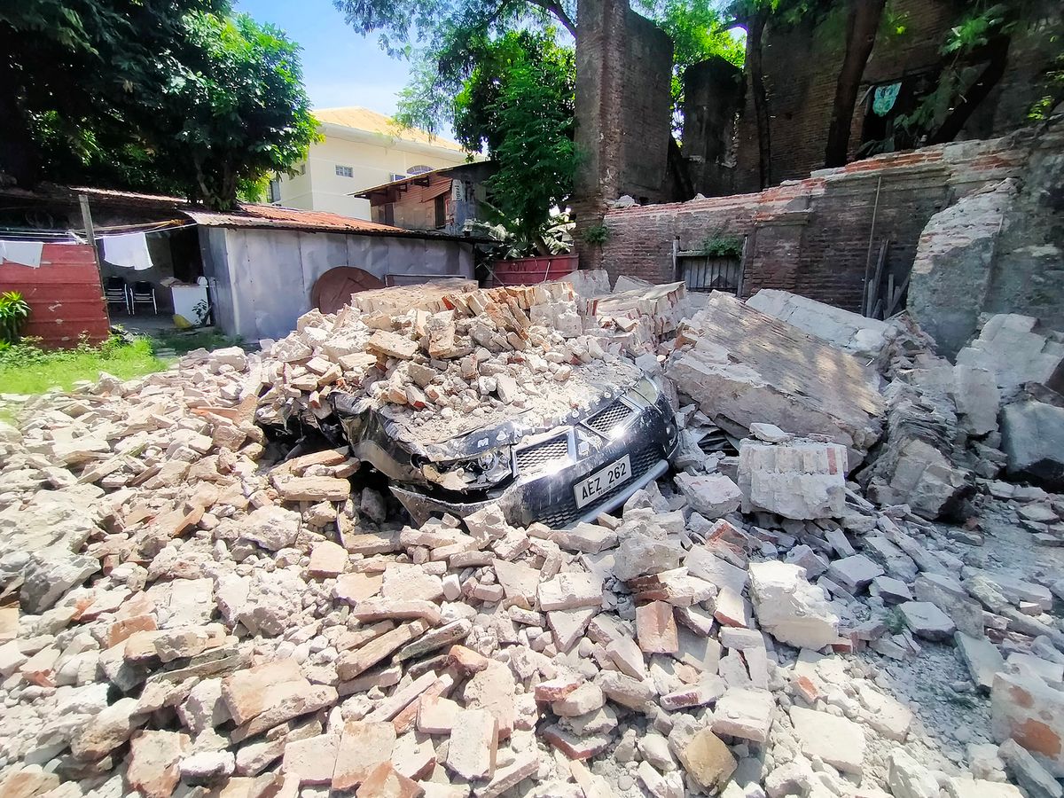 A car is buried under debris from a ruined old house in Vigan city, Ilocos Sur province north of Manila on July 27, 2022, after a 7.0-magnitude earthquake hit the northern Philippines. (Photo by Ricardo Raguini / AFP) / “The erroneous mention[s] appearing in the metadata of this photo by Ricardo Raguini has been modified in AFP systems in the following manner: [REMOVING RESTRICTIONS and changing source to AFP]. Please immediately remove the erroneous mention[s] from all your online services and delete it (them) from your servers. If you have been authorized by AFP to distribute it (them) to third parties, please ensure that the same actions are carried out by them. Failure to promptly comply with these instructions will entail liability on your part for any continued or post notification usage. Therefore we thank you very much for all your attention and prompt action. We are sorry for the inconvenience this notification may cause and remain at your disposal for any further information you may require.”