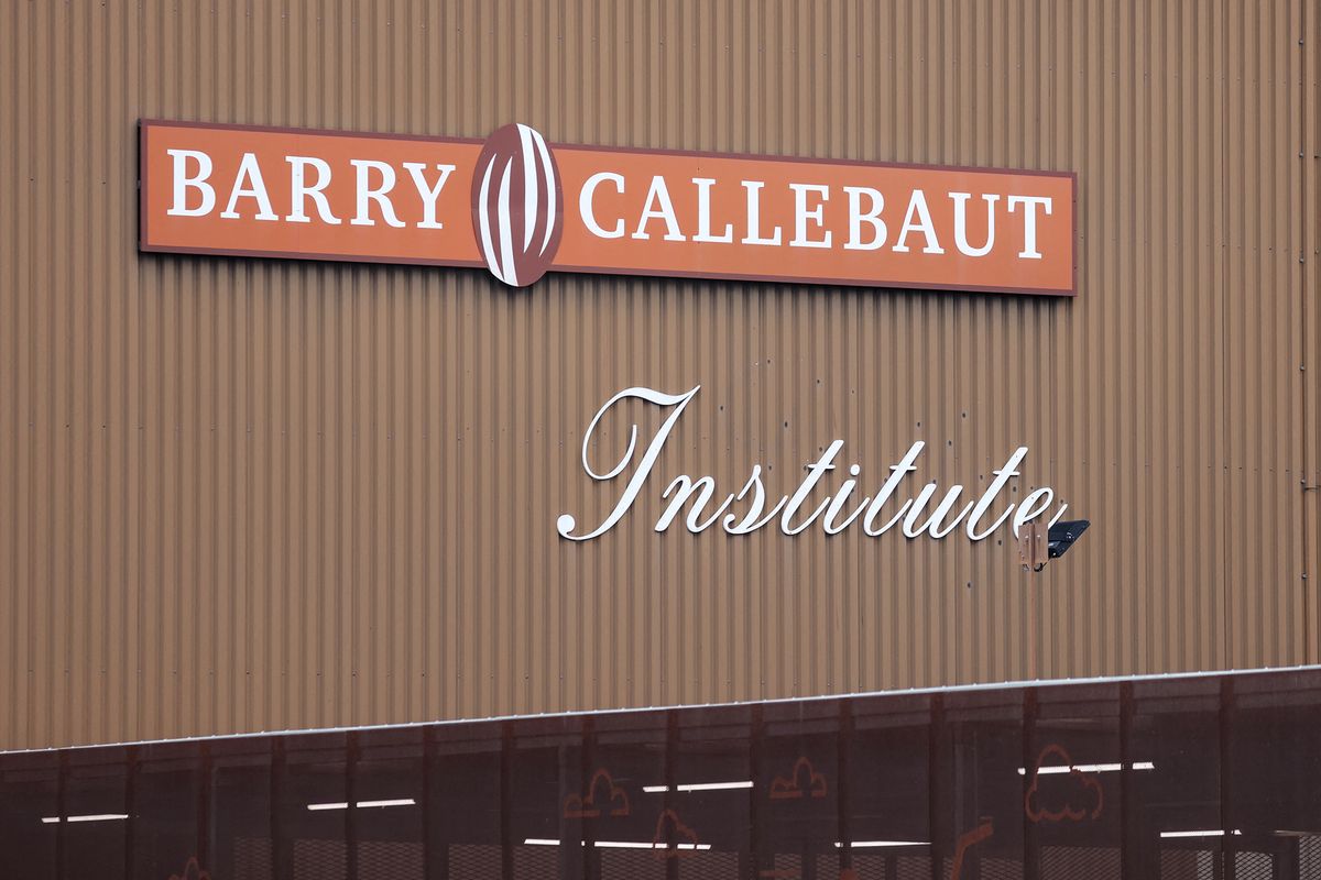 This picture taken on June 30, 2022 shows the logo of Barry Callebaut on the production site premises in Wieze, near Brussels. - Swiss group Barry Callebaut, the world's largest cocoa and chocolate company, said on June 30, 2022, that it had halted chocolate production at its Wieze (Belgium) factory, billed as the world's largest, after salmonella was found in a batch on June 26. (Photo by Kenzo TRIBOUILLARD / AFP)