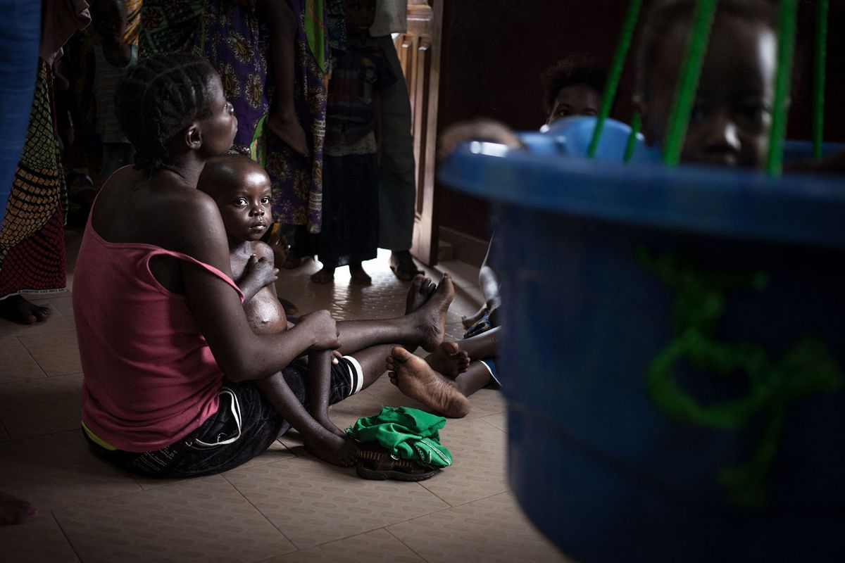 A mother waits with her malnourished child for the daily checkweighing at the Bangui paediatric complex on December 4, 2018. - In Central African Republic, infant mortality is the highest in the world, with two out of three children, or 1.5 million people, in need of humanitarian assistance, according to a UNICEF report from 2018. (Photo by FLORENT VERGNES / AFP)