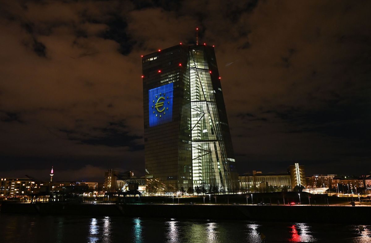 1237474475 dpatop - 30 December 2021, Hessen, Frankfurt/Main: During a test run, the euro symbol is projected onto the south facade of the European Central Bank's (ECB) headquarters in Frankfurt's East End. On New Year's Eve 20 years ago, the common European currency, the euro, was introduced in twelve EU countries. For Germany, this meant saying goodbye to the D-Mark. From 31 December 2021 to 9 January 2022, the ECB facade will be illuminated in the evening hours. Photo: Arne Dedert/dpa (Photo by Arne Dedert/picture alliance via Getty Images)