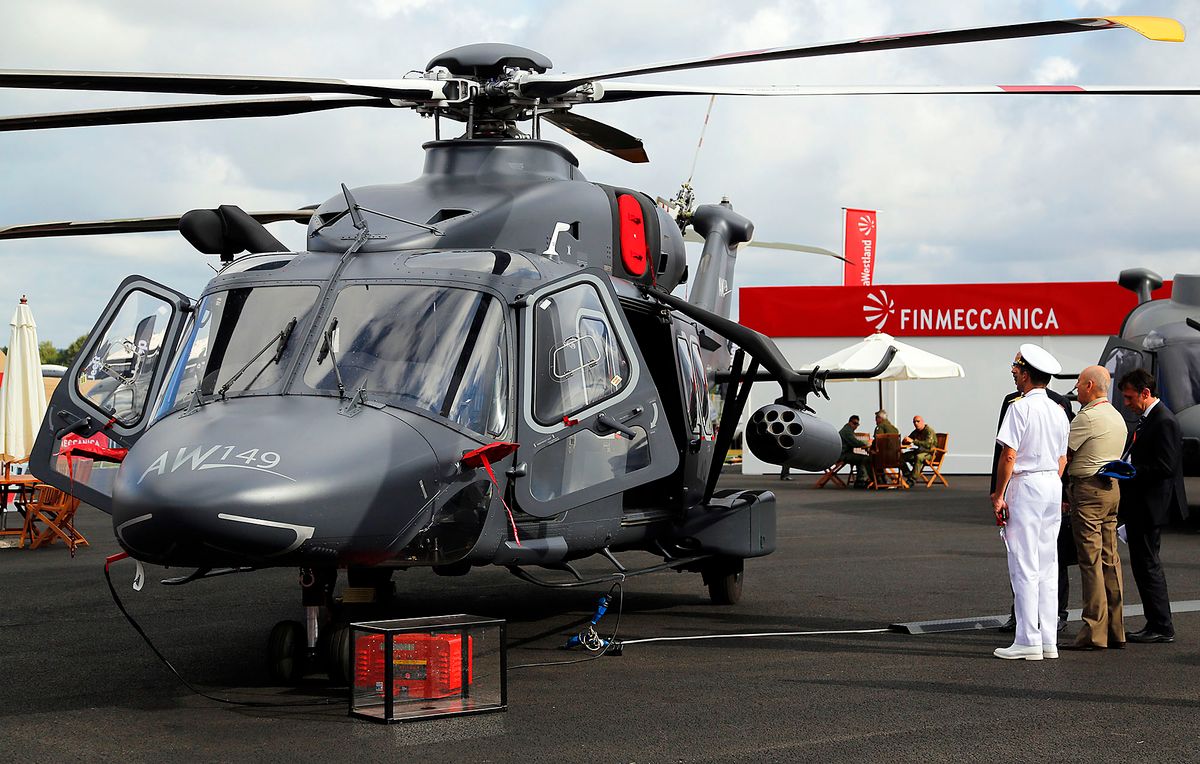 Visitors look at an AW149 military helicopter, produced by AgustaWestland, a unit of Finmeccanica SpA, as it stands on display on the second day of the Farnborough International Airshow in Farnborough, U.K., on Tuesday, July 15, 2014. The Farnborough International Air Show, which runs July 14-20, is this year's biggest forum for aircraft introductions and sales. Photographer: Paul Thomas/Bloomberg via Getty Images