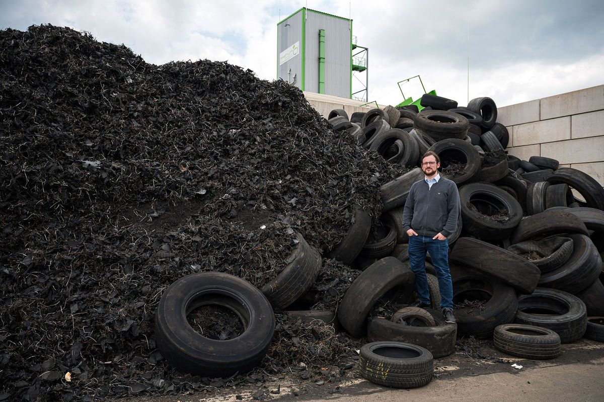 PRODUCTION - 03 May 2021, Saarland, Dillingen: Founder and CEO Pascal Klein stands on the premises of Pyrum Innovations in front of a pile of car tires, some of which have been shredded. Pyrum Innovations has developed the so-called Pyrum Thermolysis, by means of which tires are recycled. (to dpa: "New oil and new coke from old tires") Photo: Oliver Dietze/dpa (Photo by OLIVER DIETZE / DPA / dpa Picture-Alliance via AFP)