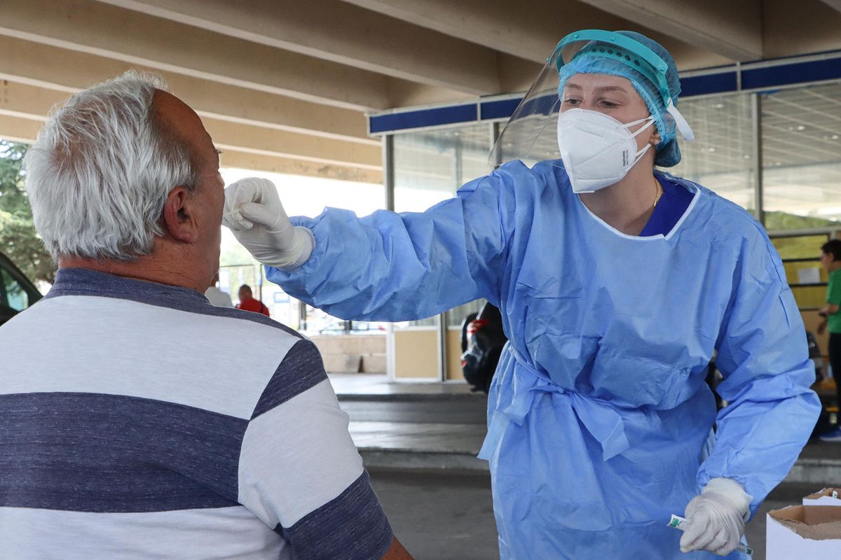 A female healthcare worker collects covid-19 sample from a male passenger. Travelers in cars and buses from all over Europe but mostly from Bulgaria, Romania, Czech Republic and Poland arrive at the Greek Bulgarian borders of Promahonas - Kulata, entering point in Greece for holidays and they are checked for Coronavirus. Greece lifted the travel ban since July 1 and relaunched the tourism season. Arriving tourists should carry the special Passenger Locator Form for each individual, a new required document to enter Greece for all the arriving people and the increased Covid-19 Coronavirus tests that are applied to most of the arriving cars, based on a special algorithm. Greece increased the testing capacity with the health crew of the National Public Health Organization EODY at the land borders. Greece will allow the entrance only to passengers with up to 72 hours prior to the arrival Covid-19 test with negative results in English from a certified laboratory. In August 2020 Greece is starting implementing new protective measures like local lockdown, changing the maximum number of people together and the working hours of restaurants, bars, beach bar etc against the spread of the pandemic outbreak, as people relax and avoid the guidelines. Until now Greece is counting 263 fatalities from the virus. On 23 August 2020 in Promachonas Borders, Greece   (Photo by Nicolas Economou/NurPhoto) (Photo by Nicolas Economou / NurPhoto / NurPhoto via AFP)
