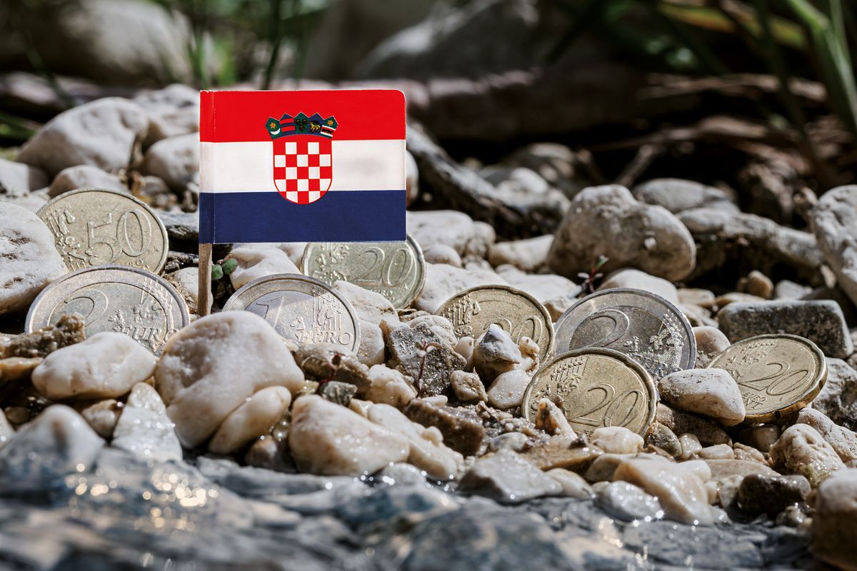 Croatia,Flag,With,Euro,Coins,Amid,Gravel,Surface,On,Croatia flag with euro coins amid gravel surface on the riverbank,currency exchange,business finance and economy concept,macro close-up