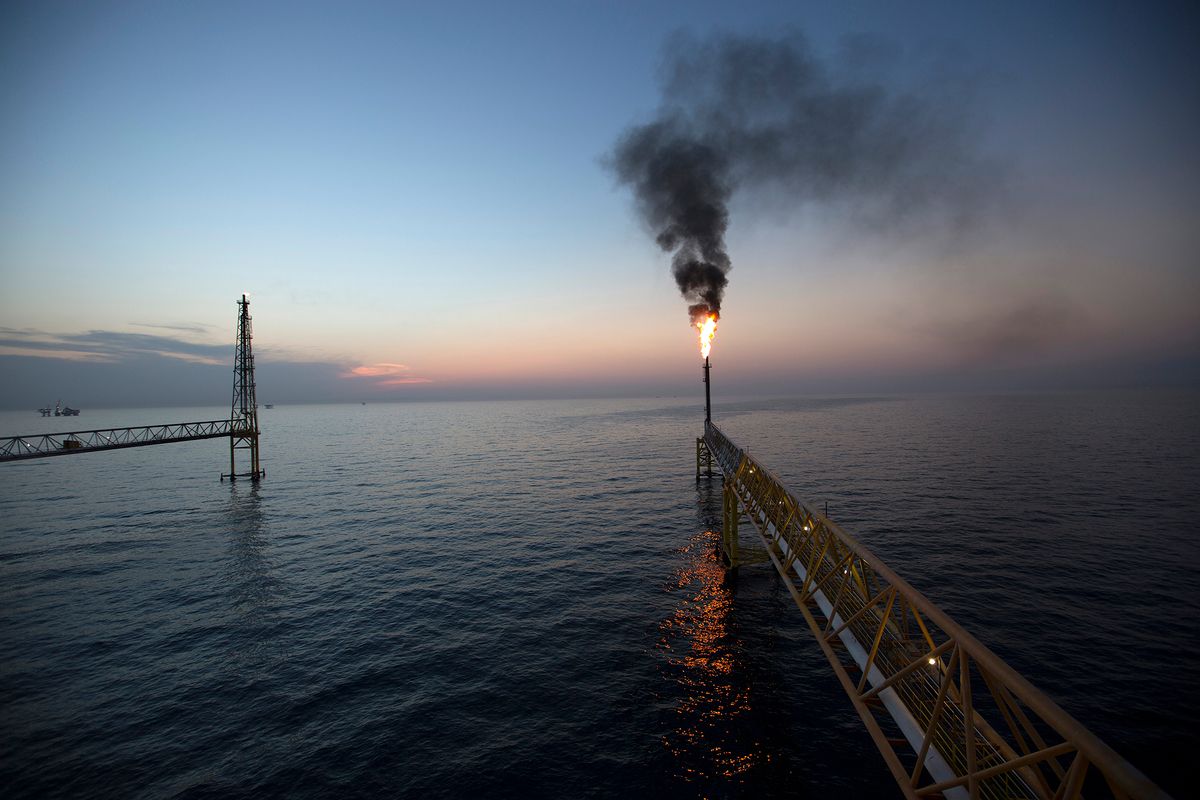 FILE PHOTO: Gas flares from a burner tower on the Petroleos Mexicanos (Pemex) Pol-A Platform complex, located on the continental shelf in the Gulf of Mexico, 70 kilometers offshore from Ciudad del Carmen, Mexico, on Friday, March 28, 2014. Oil extended losses below $60 a barrel amid speculation that OPEC's biggest members will defend market share against U.S. shale producers. 